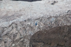 The deep blue glacier ice peeks through as the glacier creeps down, all the while receding.