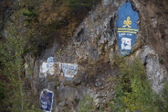Cruise line graffiti is found on the mountain rocks adjacent to the dock.