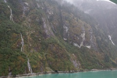 Waterfalls and glacier-carved rock walls in the fjord.